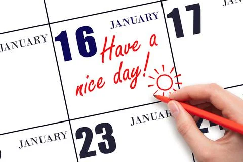 The hand writing the text Have a nice day and drawing the sun on the calendar Stock Photos