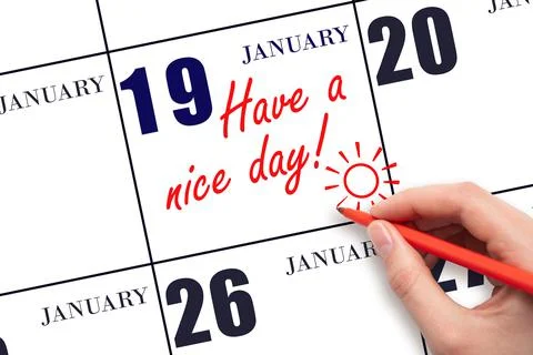 The hand writing the text Have a nice day and drawing the sun on the calendar Stock Photos