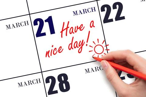 The hand writing the text Have a nice day and drawing the sun on the calendar Stock Photos