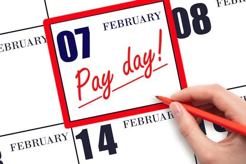 Hand writing text PAY DATE on calendar date February 7 and underline it. Pa.. Stock Photos