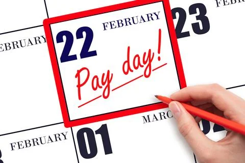 Hand writing text PAY DATE on calendar date February 22 and underline it. P.. Stock Photos