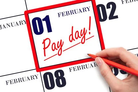 Hand writing text PAY DATE on calendar date February 1 and underline it. Pa.. Stock Photos
