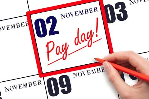 Hand writing text PAY DATE on calendar date November 2 and underline it. Pa.. Stock Photos