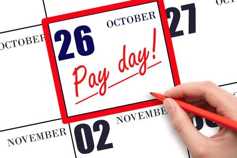Hand writing text PAY DATE on calendar date October 26 and underline it. Pa.. Stock Photos