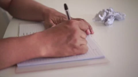 Hand writing text in spiral notepad on white table an then make mistake. Stock Footage 339122082