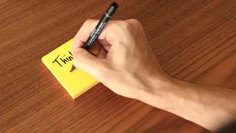 Hand Writing 'Think positive' on Sticky Note Stock Footage 328331460