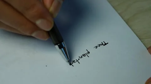 Hand writing travel plan on paper, Close-up of a hand writing a travel plan.. Stock Footage 346484041