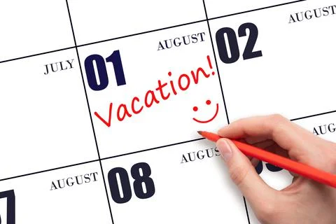 A hand writing a VACATION text and drawing a smiling face on a calendar date  Stock Photos