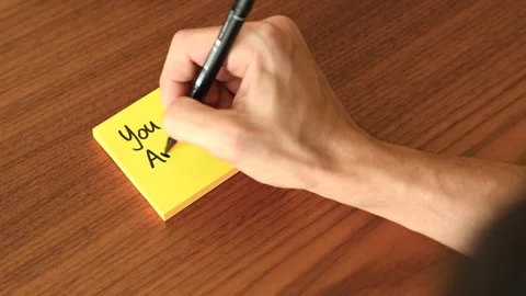 Hand Writing 'You are enough!' on Sticky Note Stock Footage 328331488