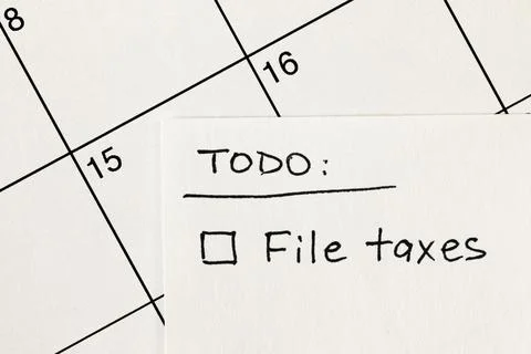 Hand written to-do list with File taxes reminder on a calendar Stock Photos