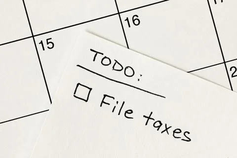 Hand written to-do list with 'File taxes' reminder written on a calendar Stock Photos