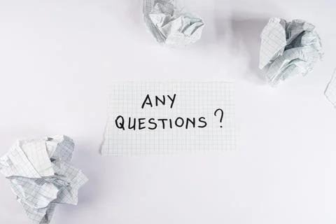 Hand written text asking any questions on a piece of grid paper surrounded .. Foto stock