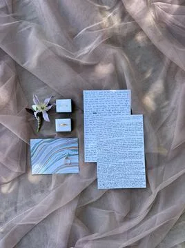 Hand-written wedding invitations next to the envelope lie on the fabric Fotos Stock