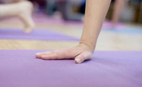 Hand on a yoga mat Stock Photos