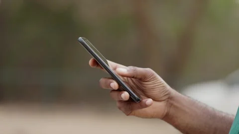 Hand of Young African Man using smartphone, orders ride outdoors. Stock Footage 345506133