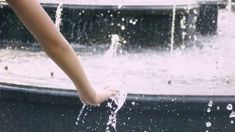 Hand of young boy playing with water of fountain Stock Footage 77429430