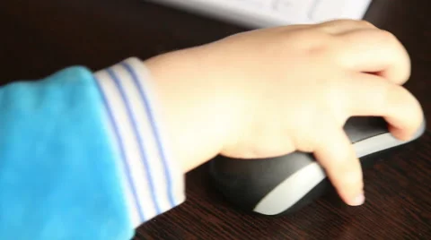 Hand of a young child moves the computer mouse on the table Stock Footage 60689368