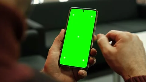 Hand of young man holding smartphone green screen in business office work Stock Footage 337299034