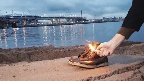 Hand of young man Igniting boots near the waterfront Stock-Footage 69164255
