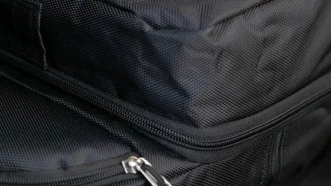 Hand of a young man makes the zipper a suitcase in the trunk of a car Stock Footage 87272412