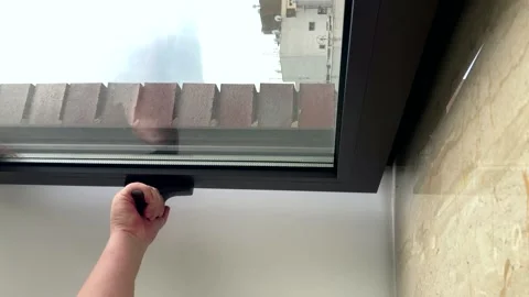 The hand of a young man opens and closes a plastic window at home.vertical Stock Footage 245371805