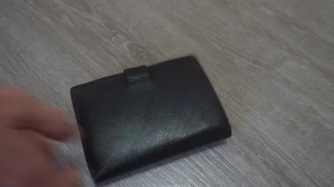 The hand of the young man puts on the table a wallet,smartphone and keys,concept Видео 83627147