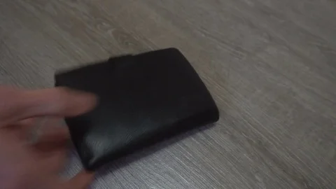 The hand of the young man puts on the table a wallet,smartphone and keys,concept Stock Footage 83628053