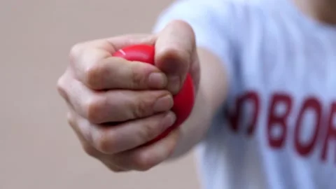 Hand of young man squeezes rubber ball to do rehabilitation exercises Stock Footage 231676381