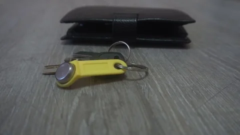 The hand of the young man takes the keys and wallet from the table,the concept Video stock 83629970