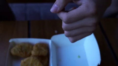 The hand of the young man takes out a box of chicken nuggets 動画素材 76893750