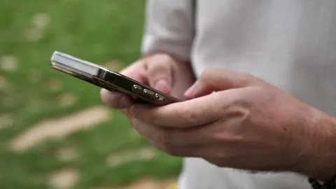 Hand of young man using mobile phone, writing message and browsing news online Stock Footage 281599289