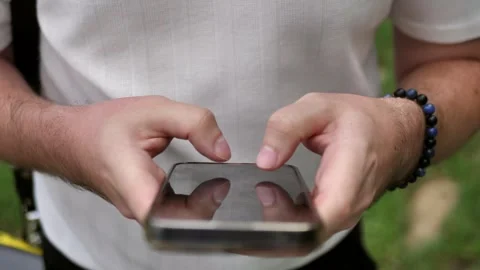 Hand of young man using mobile phone, writing message and browsing news online Stock Footage 281599291