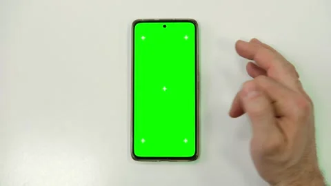 Hand of young man using mobile phone with green screen on white surface Stock Footage 297946460