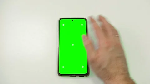 Hand of young man using mobile phone with green screen on white surface Vídeo Stock 301074659