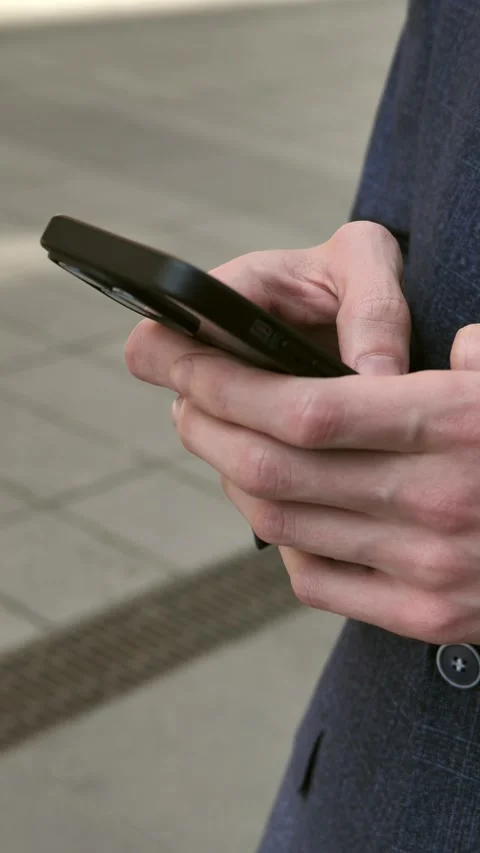 Hand of young man using mobile phone, writing message and browsing internet news Stock Footage 309322582