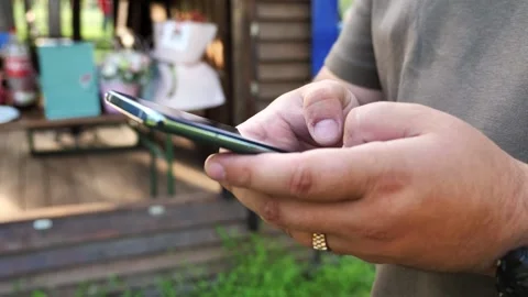 Hand of young man using mobile phone, writing message and browsing internet Stock Footage 334723227