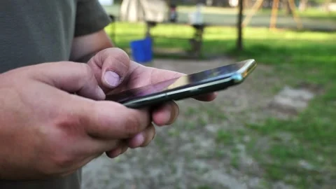 Hand of young man using mobile phone, writing message and browsing internet Stock Footage 334723346