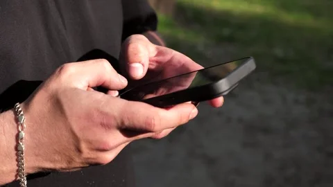 Hand of young man using mobile phone, writing message and browsing internet Stock Footage 334723415