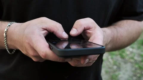 Hand of young man using mobile phone, writing message and browsing internet Stock Footage 334723424