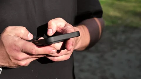 Hand of young man using mobile phone, writing message and browsing internet Stock Footage 334723444