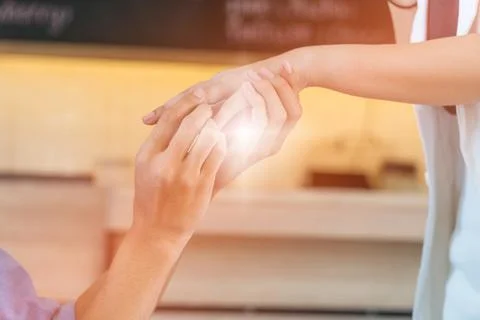 Hand young man wearing a ring with a beautiful woman's hand. Stock Photos