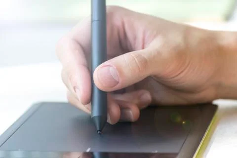 Hand of a young man writes on a graphics tablet Foto stock