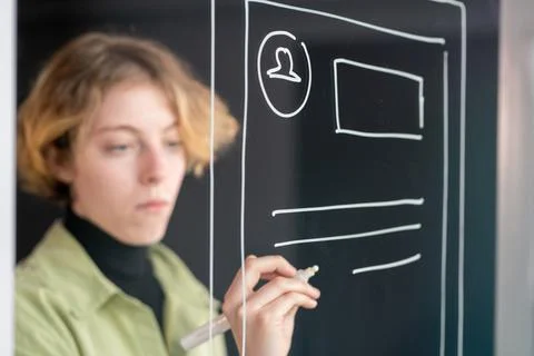 Hand of young serious mobile application developer drawing new sketches Stockfoto's