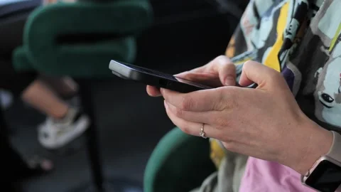 Hand of a young woman using a mobile phone reads a phone message or downloads a Stock Footage 244893718