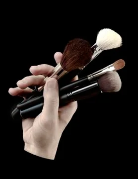 Hand_with_brushes_for_make-up Stock Photos