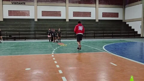 Handball coach teaching young players indoor court Stock Footage 345591637