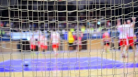 Handball match scene with goalpost net and players in the background Видео 70085899
