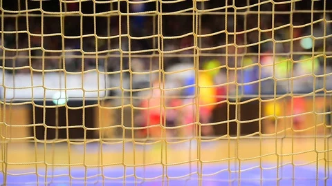 Handball match scene with goalpost net and players in the background Stockbeeldmateriaal 70086412