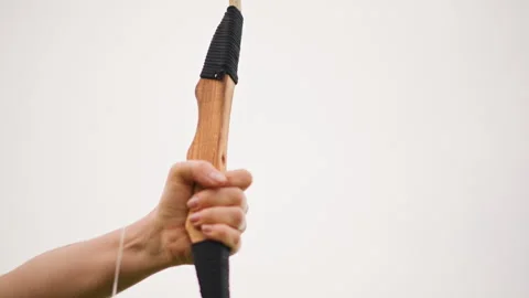 Handcrafted bow with focused shot, Skillful archer drawing bow against calm sky Stock Footage 329404233