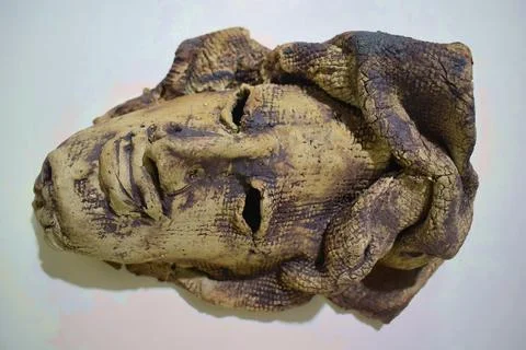 Handcrafted ceramic face relief with expressive features Stock Photos